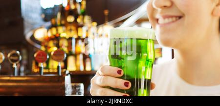 Nahaufnahme der Frau mit grünen Bier im Glas Stockfoto