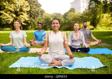Eine Gruppe von Menschen, die im Sommerpark Yoga machen Stockfoto