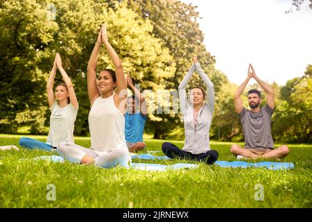 Eine Gruppe von Menschen, die im Sommerpark Yoga machen Stockfoto