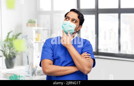 indischer Arzt in blauer Uniform und Maske Stockfoto