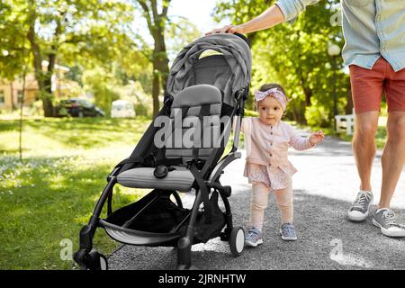 Vater mit Kind im Kinderwagen im Sommerpark Stockfoto