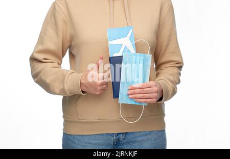 Frau mit Maske, Reisepass und Flugticket Stockfoto