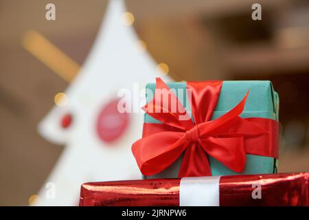 Eine Nahaufnahme einer geschenkschachtel zu Weihnachten, die in ein rotes Band gehüllt ist Stockfoto