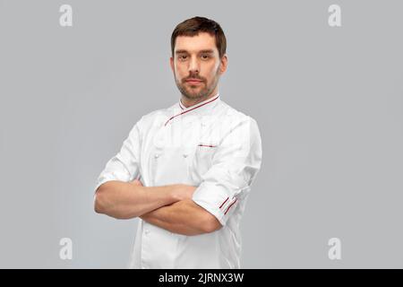 Fröhlich lächelnder männlicher Koch mit gekreuzten Armen Stockfoto