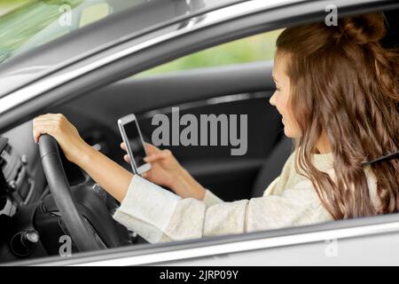 Lächelnde Frau oder Fahrerin, die in der Stadt Auto fährt Stockfoto