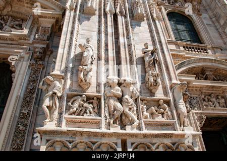 Nahaufnahme der verzierten Statuen und Skulpturen an der Außenseite des Mailänder Doms. Wunderschöne Marmorschnitzereien - Mailand, Italien Stockfoto