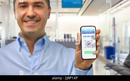 Mann mit Impfpass auf dem Smartphone Stockfoto