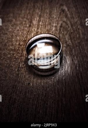 Eine vertikale Aufnahme einer kleinen Lupe auf einem Holztisch Stockfoto