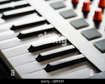 Nahaufnahme. Tasten einer modernen Midi-Tastatur. Aufnahmestudio. Moderne Musikausrüstung für professionelle Aktivitäten. Musiker, Komponist, Toningenieur. Stockfoto