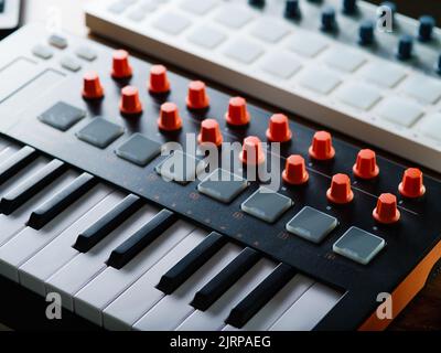 Nahaufnahme. Moderne Midi-Tastatur. Professionelles Musikinstrument für Aufnahmestudio, Musikstudio. Soundarbeit, Podcast, Arrangement, Musik, Gesang. Stockfoto