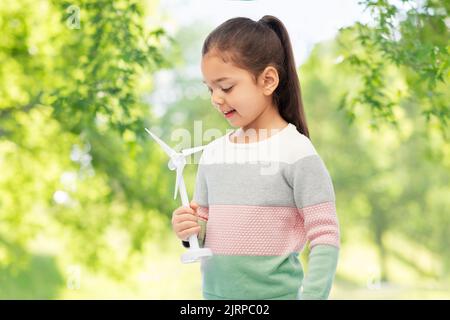 Mädchen mit Spielzeug Windturbine über natürlichen Hintergrund Stockfoto