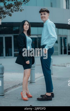 Ein Geschäftsmann und eine junge Frau, die in ihrer Arbeitspause im Freien stehen Stockfoto