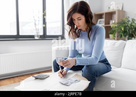 Frau, die zu Hause Geld zählt Stockfoto