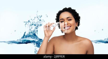 Glückliche junge afroamerikanische Frau mit Augentropfen Stockfoto