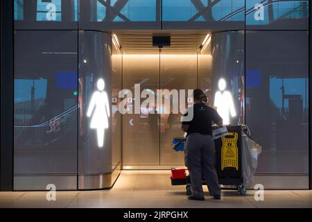 Eine Putzfrau bereitet sich darauf vor, die Damen zu betreten und zu reinigen, weibliche Loos (links) und männliche Toilette/Toiletten/Toilette/Toilette/Zugang zum Eingang (betreten ohne Tür) Flughafen Genf, Schweiz (131) Stockfoto