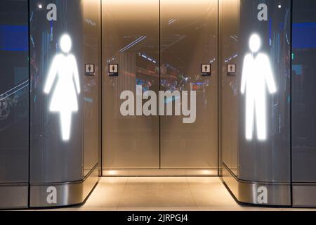 Damen weibliche Loos (links) und männliche Toilette / Toiletten / Toilette / Eingang Zugang (ohne Tür) Flughafen Genf, Schweiz. (131) Stockfoto