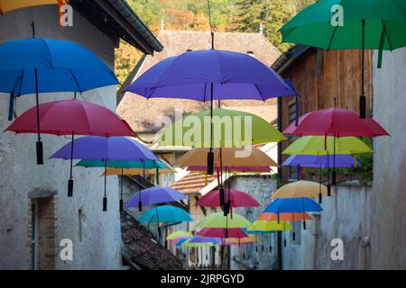 Regenschirm-Kunstinstallation mit hängenden Regenschirmen auf der Straße für die Wertschätzung der Touristen in Chanaz; französische Gemeinde im Département Savoie in der Region Auvergne-Rhône-Alpes im Südosten Frankreichs. (131) Stockfoto