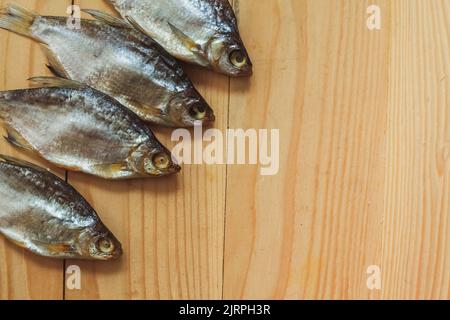 Getrockneter gesalzener Fisch auf einem hölzernen Hintergrund. Fischsnacks. Getrockneter Fisch für Bier. Stockfoto