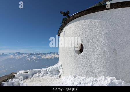 Ein Detail des abgerundeten Daches der Hafelekar-Bergstation der Nordkettte-Seilbahn, oberhalb von Innsbruck; ein Alpine Chough liegt am Dach Stockfoto