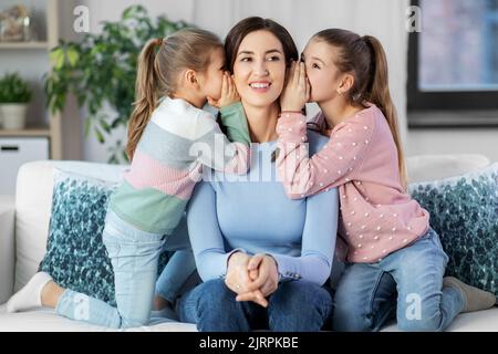 Glückliche Mutter und Töchter, die zu Hause klatschen Stockfoto
