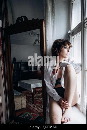 Mädchen am Fenster im alten Haus Stockfoto