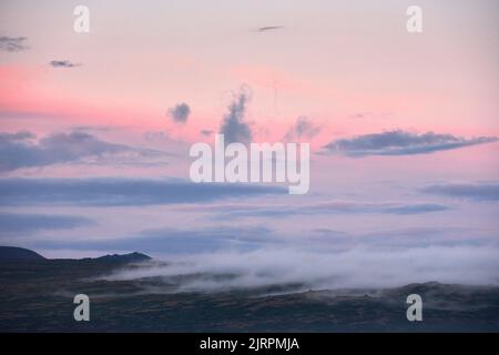 Leuchtend rosa Sonnenuntergang Himmel über bergigen Tal Stockfoto