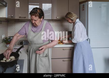 Zwei Frauen, Mutter und Tochter, kochen Kuchen in der Küche. Stockfoto