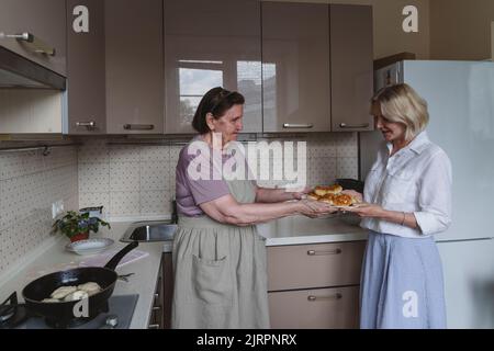 Zwei Frauen, Mutter und Tochter, kochen Kuchen in der Küche. Stockfoto