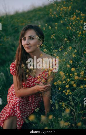 Porträt eines Mädchens im Sommer auf dem Gras geschnitten gelben Wildblumen Stockfoto