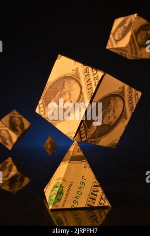 Dollarwürfel balanciert auf Dollarpyramide Stockfoto