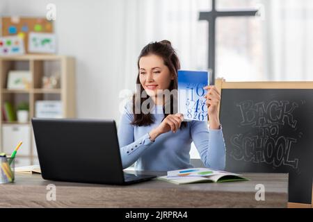 Mathelehrerin mit Buch mit Online-Unterricht zu Hause Stockfoto