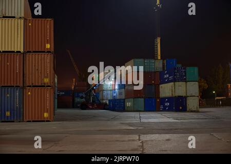 Odessa, Ukraine SIRCA 2019: Betrieb des Containerterminals in der Nacht. Nächtliches Entladen des Containerschiffes. Stapel von Containern am Terminal Stockfoto