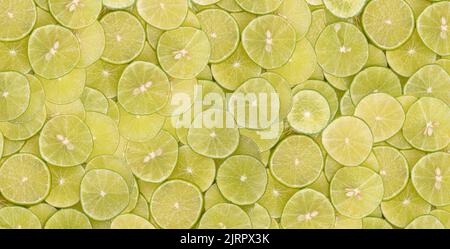 Aufgeschnittene grüne Limetten, die in Stapeln übereinander gestapelt sind. Stockfoto