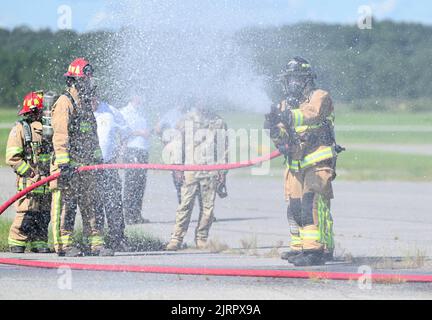 Die Feuerwehrleute der US-Luftwaffe vom 908. Civil Engineer Squadron testen verschiedene Strömungsmuster der Löschschlauchdüse während einer gemeinsamen Interoperabilitätsübung am 4. August 2022 in Fort Benning, Georgia. Die Trainingsübung war eine einzigartige Gelegenheit für 908. CES Feuerwehrleute, sich mit einem Helikoptertrainer auf die neue MH-139A Grey Wolf Hubschraubermission des Airlift Wings 908. vorzubereiten und gleichzeitig ihre jährlichen Anforderungen zu erfüllen. (USA Luftwaffe Foto von Airman 1. Klasse Juliana Todd) Stockfoto