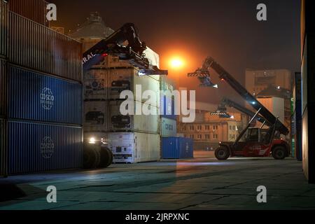 Odessa, Ukraine SIRCA 2019: Betrieb des Containerterminals in der Nacht. Nächtliches Entladen des Containerschiffes. Stapel von Containern am Terminal Stockfoto