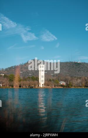 Eine vertikale Aufnahme eines ruhigen Sees mit einem schönen Glockenturm in Greenville von der Furman University Stockfoto