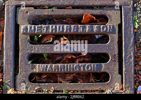 Geprägte gusseiserne Gitterroste aus Gusseisen mit Warrington-Prägung, Cheshire, England, UK, WA1 1NN Stockfoto