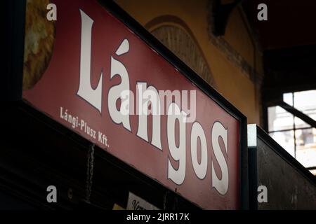 Bild eines Schildes mit Langos in Budapest, Ungarn. Langos ist ein typisches ungarisches Straßenessen. Heute ist es ein frittiertes Fladenbrot, aber in der pa Stockfoto