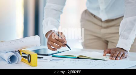 Architekt, Schreiben und Planen mit einem Geschäftsmann, der in seinem Büro ein Notizbuch mit einer Blaupause und einem Plan auf einem Tisch zeichnet. Konstruktion, Ingenieur Stockfoto