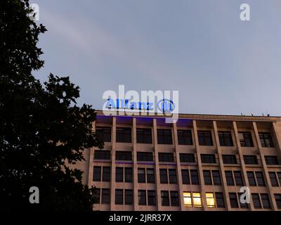 Allianz Finanzdienstleister in der Innenstadt. Bürogebäude mit einem beleuchteten Schild auf dem Dach. Geschäftsarchitektur für die Versicherung Stockfoto