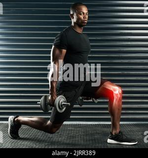 Du musst diese Zahlen aufpumpen. Ganzkörperportrait eines athletischen jungen Mannes, der mit Kurzhanteln im Studio trainiert. Stockfoto