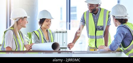 Team von Wirtschaftsingenieurinnen und Wirtschaftsingenieurinnen, die in einem Geschäftstreffen mit Papierdokumenten arbeiten. Geschäftsleute arbeiten zusammen oder arbeiten an kreativen Projekten Stockfoto