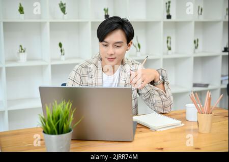 Intelligente und professionelle junge asiatische männliche Freiberufler oder Business-Startup-Unternehmer mit Laptop-Computer, Planung seiner Projektarbeit. Stockfoto
