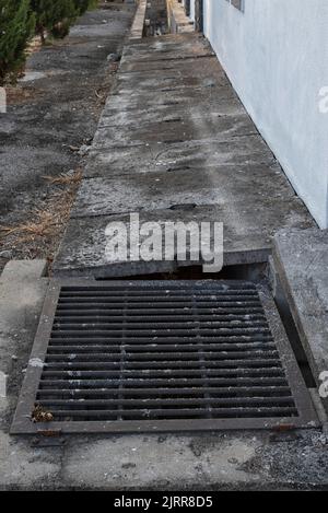 Betonentwässerungssystem im Freien an den Wohnhäusern. Stockfoto
