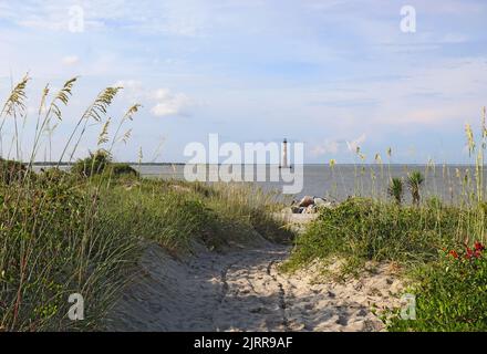 Lighthouse Inlet Heritage Preserve am nördlichen Ende von Folly Island, South Carolina, mit dem Leuchtturm von Morris Island im Hintergrund Stockfoto