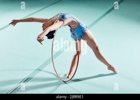 Sportlerin, Leistungs- und Balanciering für Gymnastikshow. Fitness-Mädchen tun künstlerische Pose und strecken für acrobat Stunt. Jung und schön Stockfoto