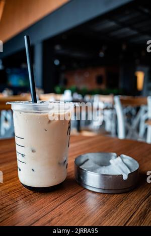 Eiskaffee in einer Plastiktasse in einem Café serviert. Urbaner Lebensstil Stockfoto