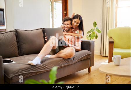 Entspannen, lieben und Laptop mit einem Paar im Internet zu Hause am Wochenende zusammen. Vielfältige, junge und glückliche Männer und Frauen, die sich im Leben entspannen Stockfoto