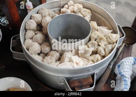 Leckeres indonesisches Street Food Bakwan Malang mit gedämpften Fleischbällchen, Knödeln und Tofu mit Suppe auf einem Puschcart. Stockfoto