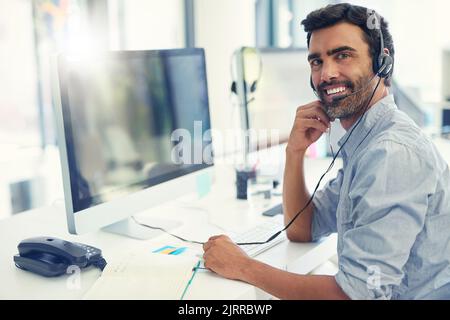 Bereit, Ihnen den zuverlässigsten Kundensupport zu bieten. Porträt eines Call Center-Agenten, der in einem Büro arbeitet. Stockfoto